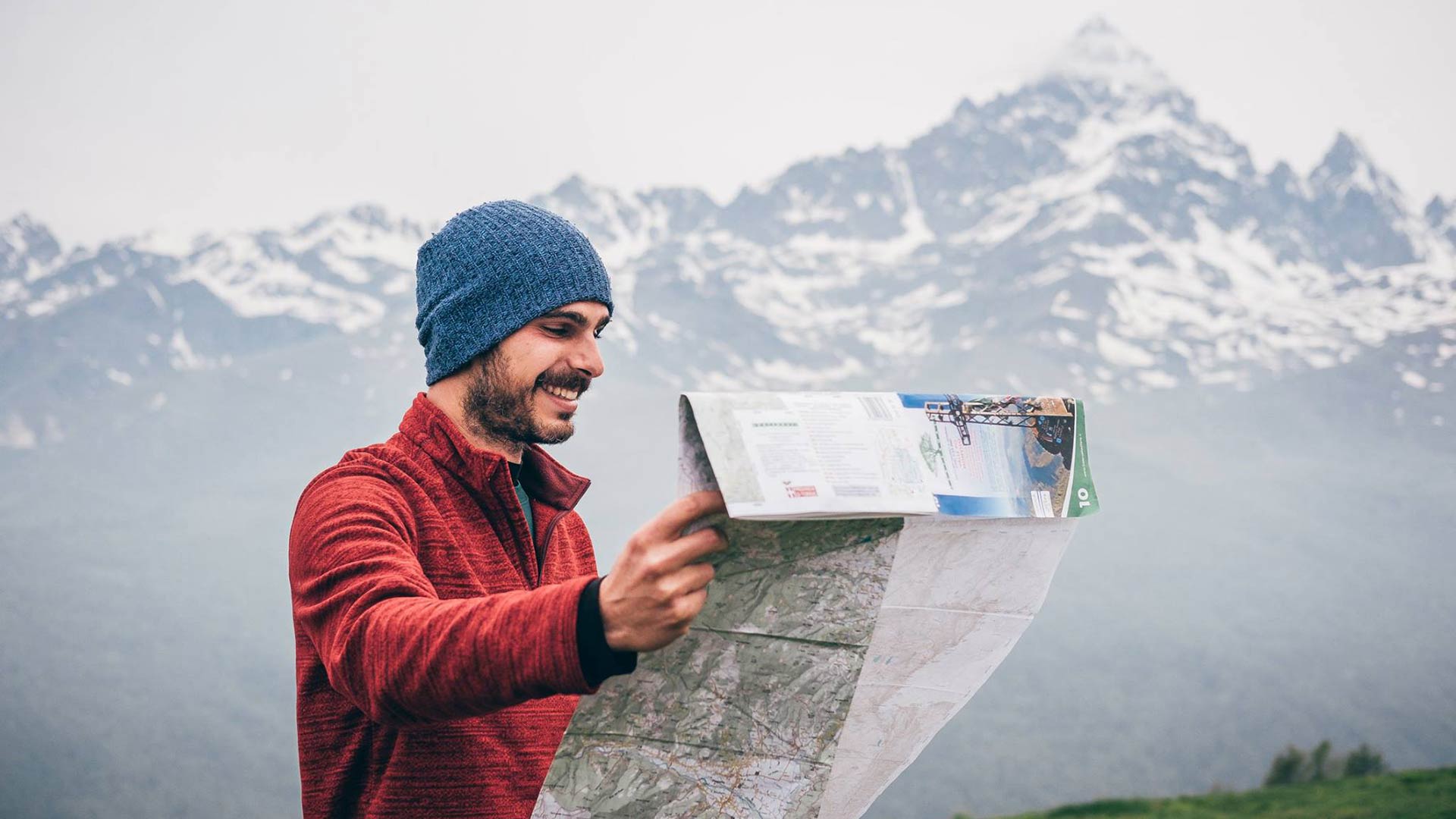 Guida escursionistica che legge la cartina davanti al Monviso