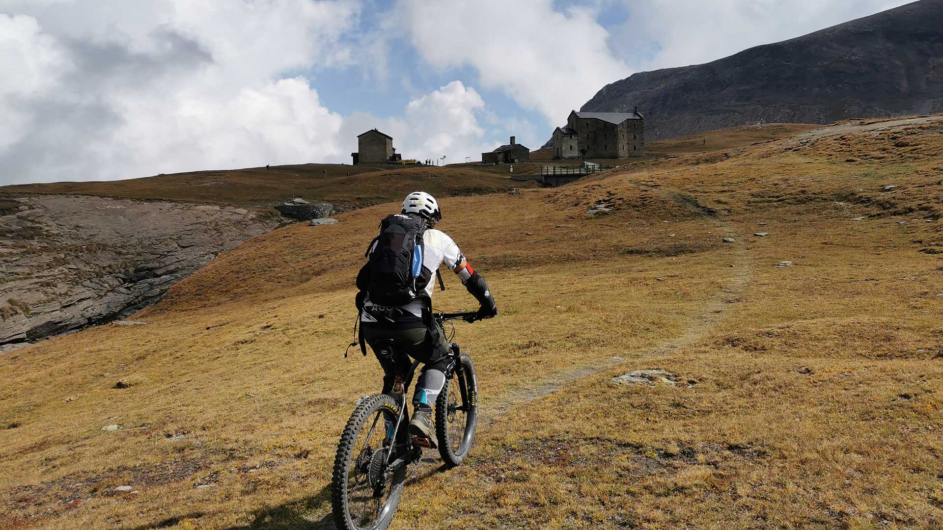 Biker in mountain bike su un sentiero d'alta quota nel Parco Nazionale del Gran Paradiso